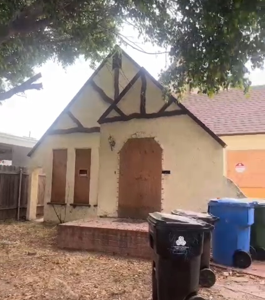 Glenhurst Avenue rear structure before construction — boarded-up doorway and cracked stucco